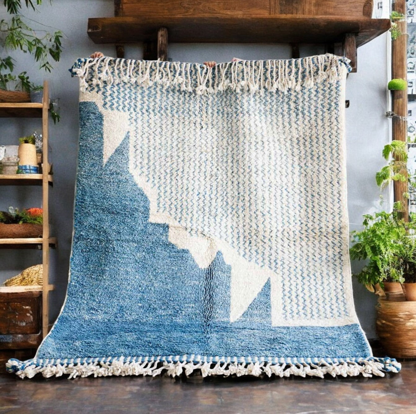Handmade wool rug featuring a soothing sky blue and white color palette with intricate geometric patterns, accented by delicate fringe detailing, displayed on a warm wooden floor.