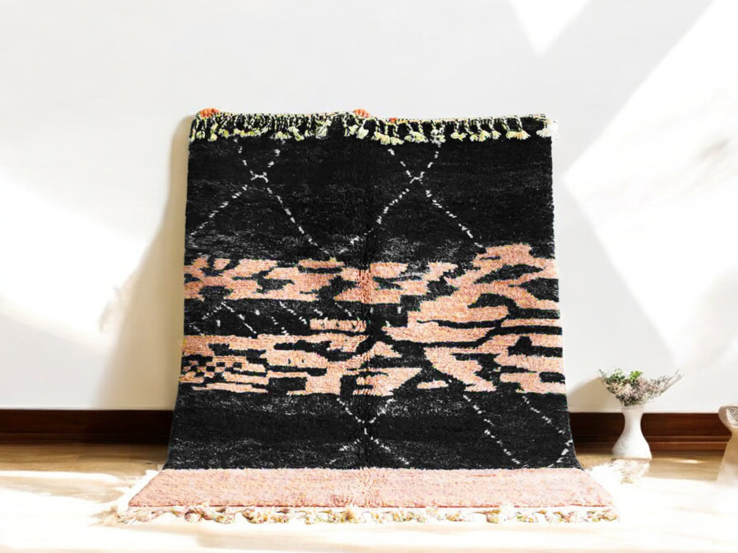 Handmade Moroccan wool rug featuring a bold black and peach abstract pattern with fringed edges, ideal for modern, boho, or eclectic interiors