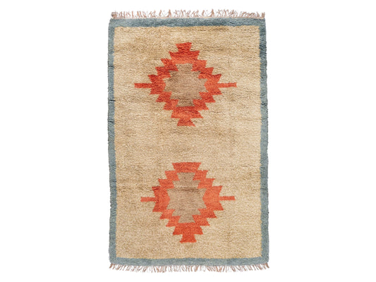 A Moroccan rug showcasing vibrant terracotta geometric medallions on a beige background, framed with a blue border. This handwoven wool rug adds warmth and a vintage touch to bohemian or rustic interiors.
