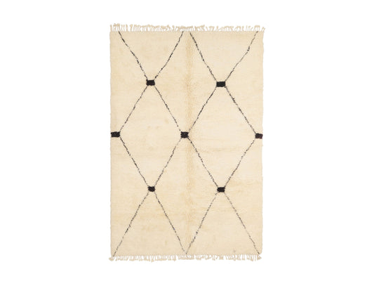 A classic Moroccan Beni Ourain shag rug in cream with a bold black diamond pattern and darkened intersections, featuring tassel fringes. Crafted from natural wool, this rug adds warmth and sophistication to any space, available in custom sizes.
