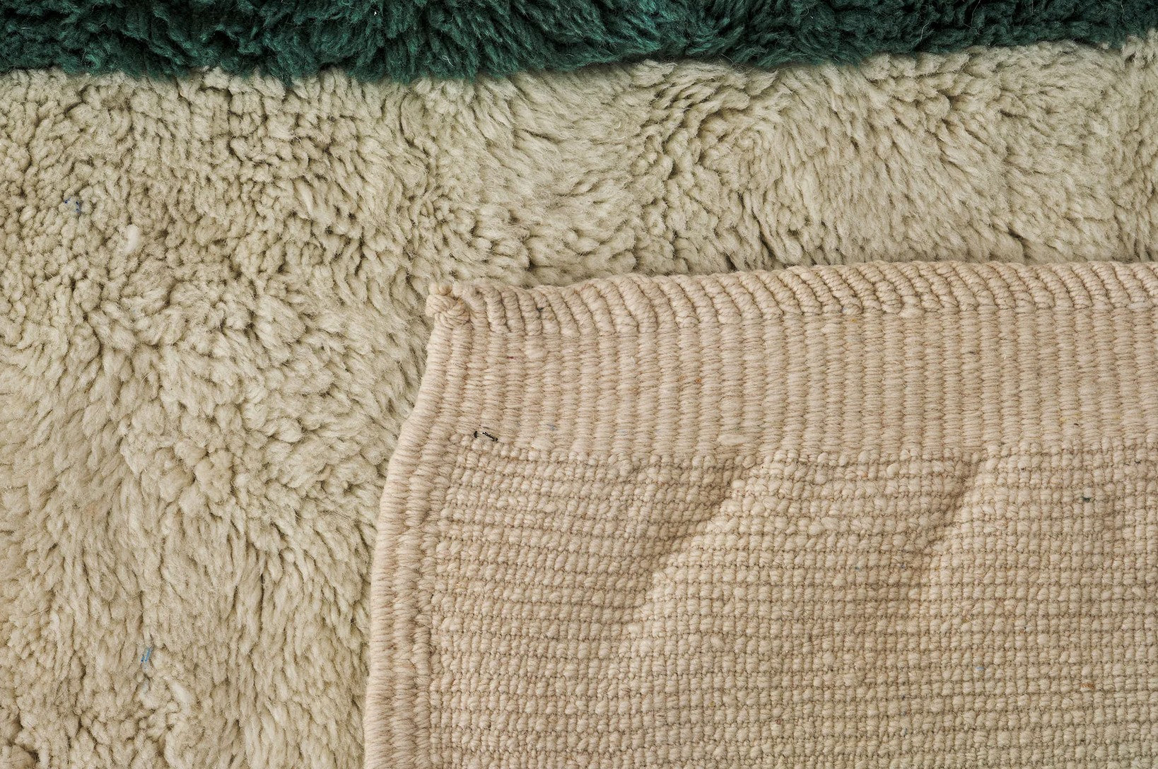 A modern Moroccan rug with bold green geometric stripes on a cream wool base, blending minimalist design and craftsmanship. Handcrafted and available in custom sizes for contemporary interiors.
