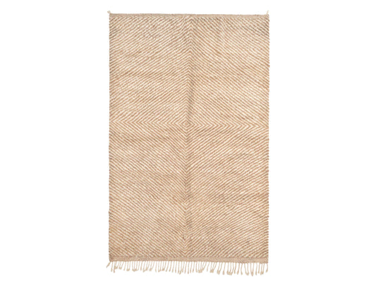 A modern Moroccan rug in beige and cream with a diagonal herringbone pattern and tasseled edges, crafted from natural wool. This rug adds a touch of texture and elegance to contemporary interiors and is available in custom sizes.
