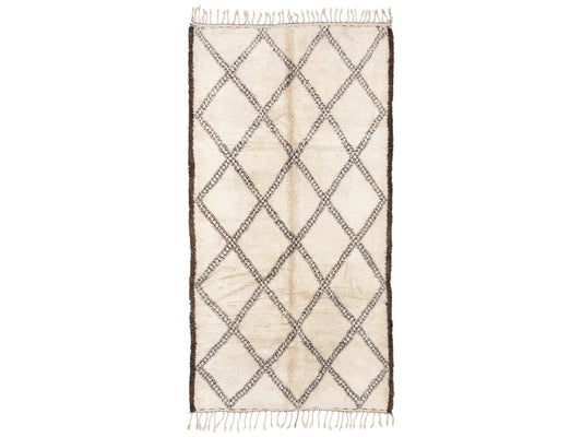A traditional Moroccan shag rug in cream with a bold brown diamond pattern and tasseled edges, made from natural wool. This rug adds warmth and Moroccan charm to any space and is available in custom sizes.
