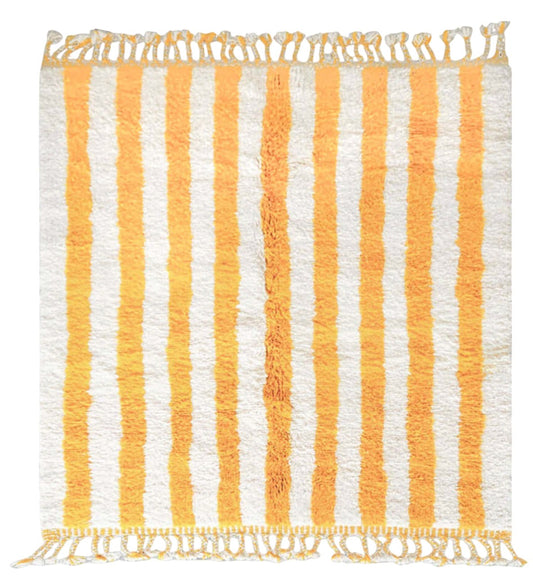 Artisanal handmade wool rug featuring bold yellow and white vertical stripes, accented by intricate fringe detailing, displayed on a neutral gray background, ideal for bright and cheerful modern decor.