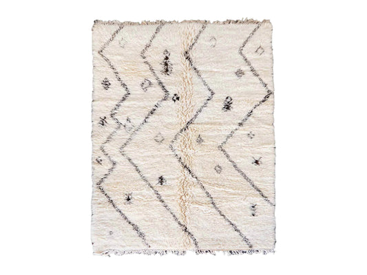 Artisanal handmade wool rug in soft white, featuring minimalist black zigzag and diamond-shaped patterns, designed for a modern, bohemian, or Scandinavian-inspired decor style.