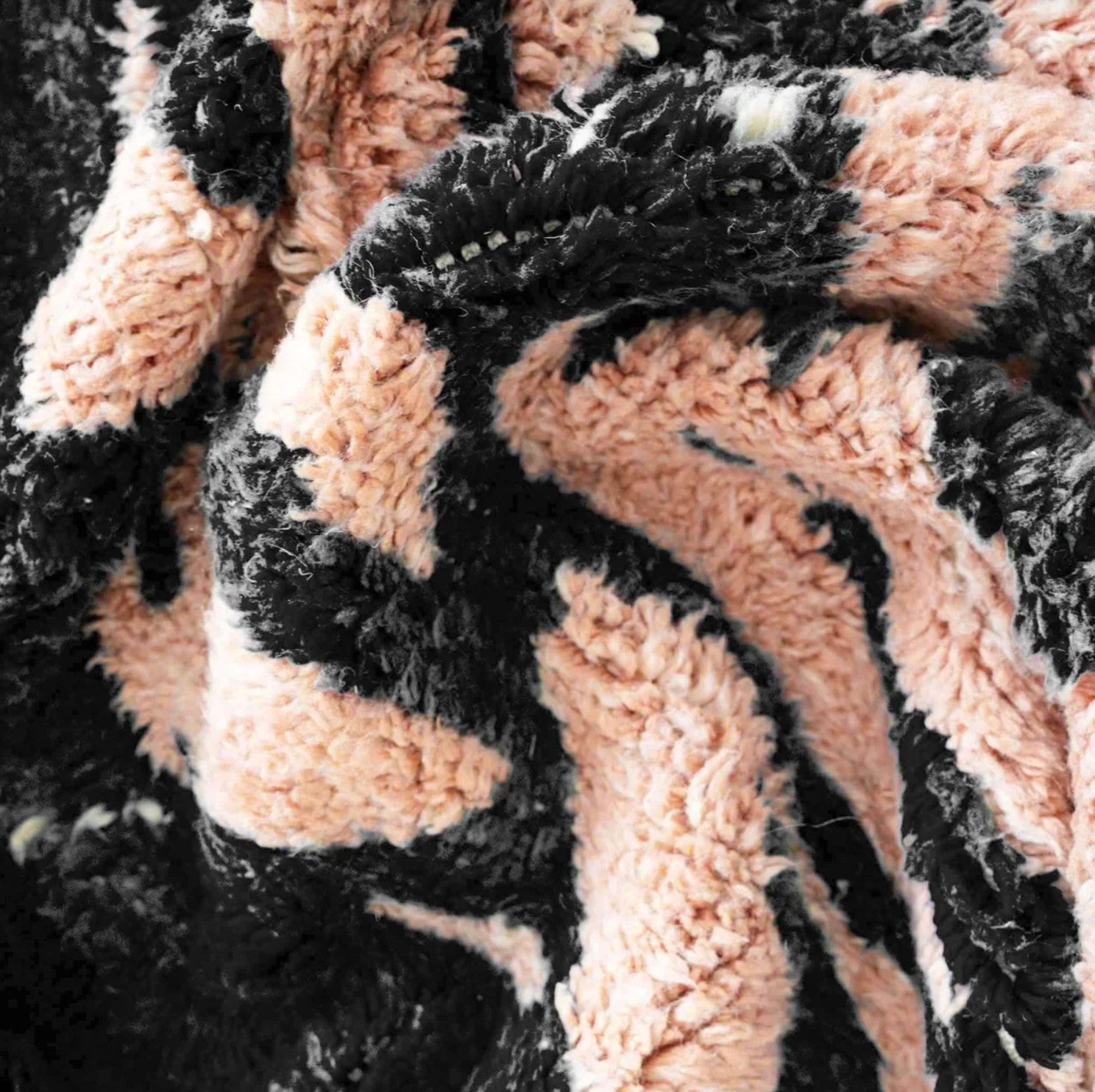 Handmade Moroccan wool rug featuring a bold black and peach abstract pattern with fringed edges, ideal for modern, boho, or eclectic interiors
