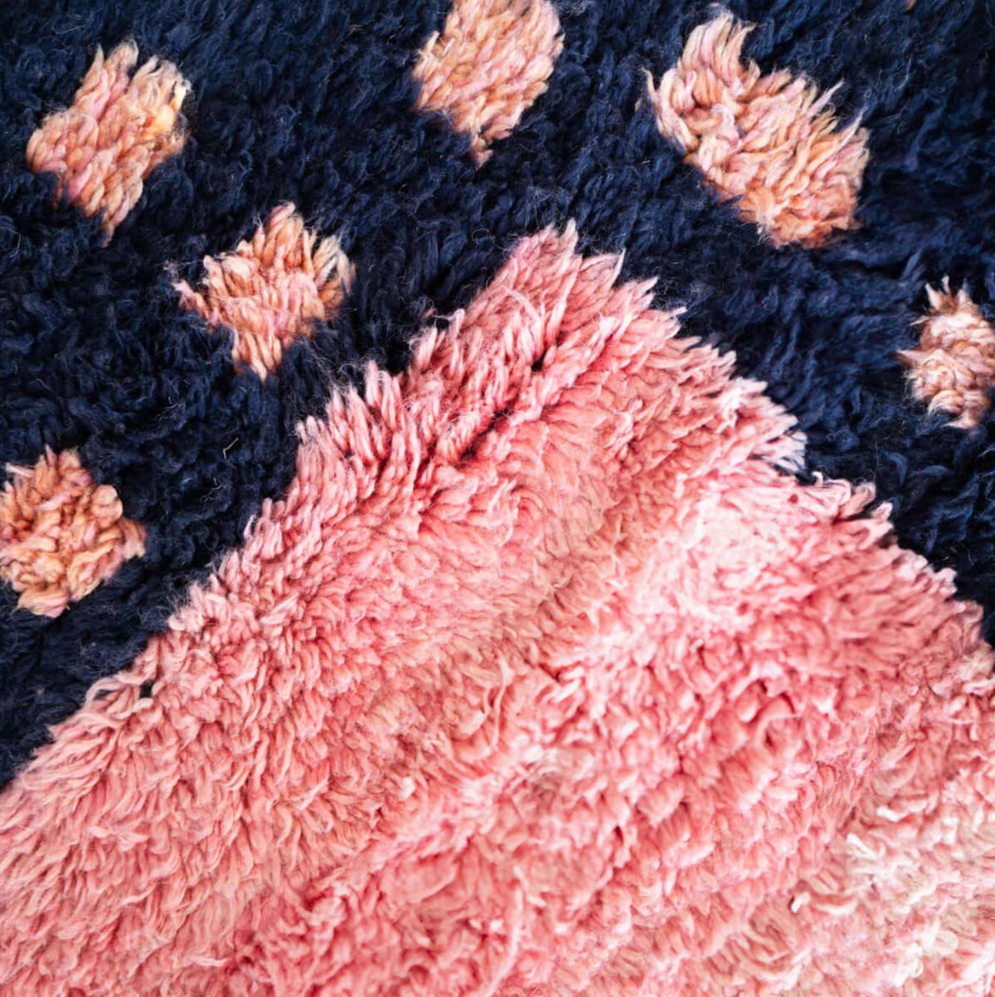 Handmade Moroccan wool rug featuring a vibrant pink center with a navy checkered border and fringed edges, creating a bold and stylish look for modern, boho, or eclectic interiors

