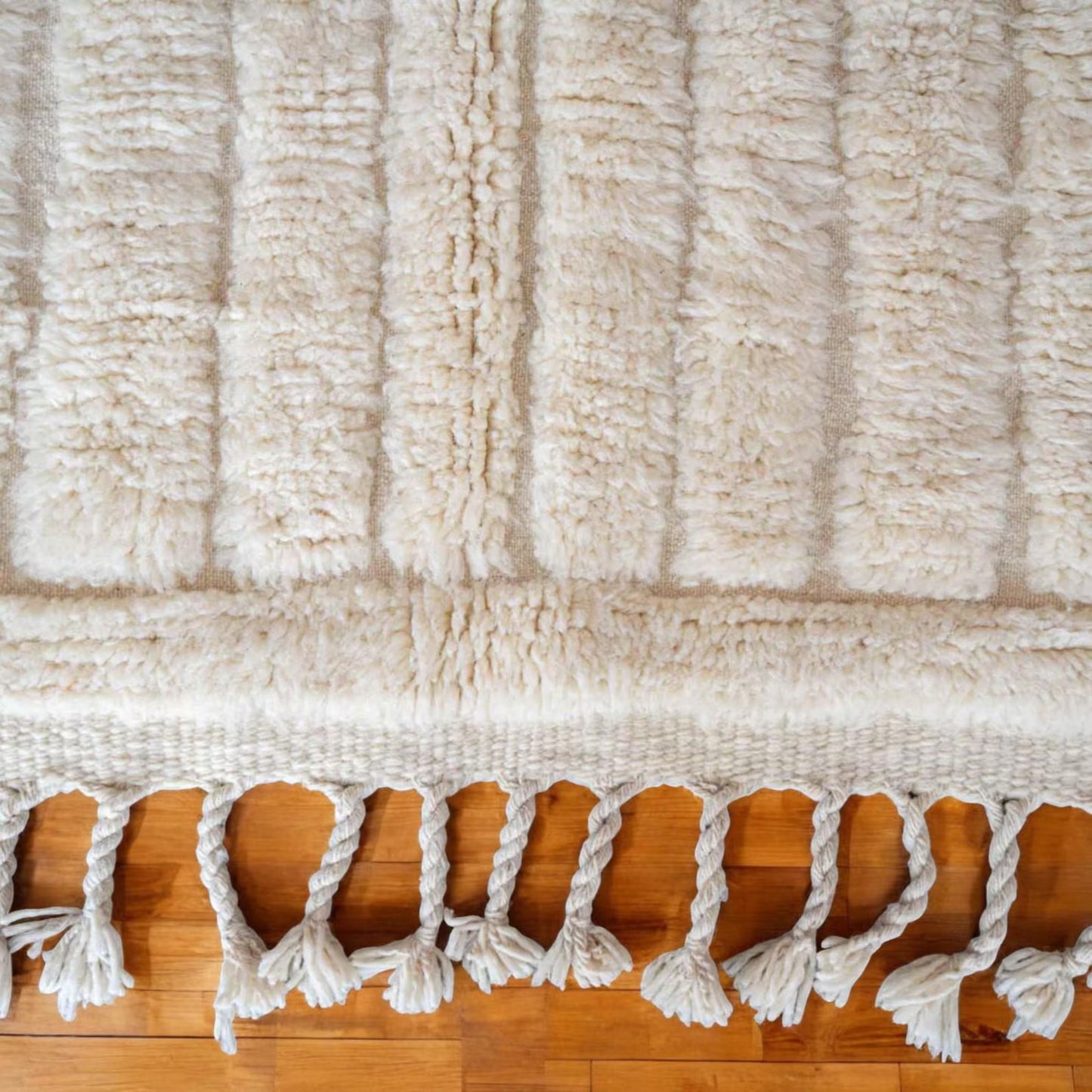 This handmade Moroccan rug features a luxurious cream white wool texture with a minimalist grid pattern. Ethically handwoven by Berber women in the High Atlas Mountains, it brings softness, warmth, and authenticity to any living room, bedroom, or serene corner. Perfect for Japandi, boho, minimalist, or modern interiors. Crafted from 100% natural wool with exquisite care. Custom sizing available for your space.