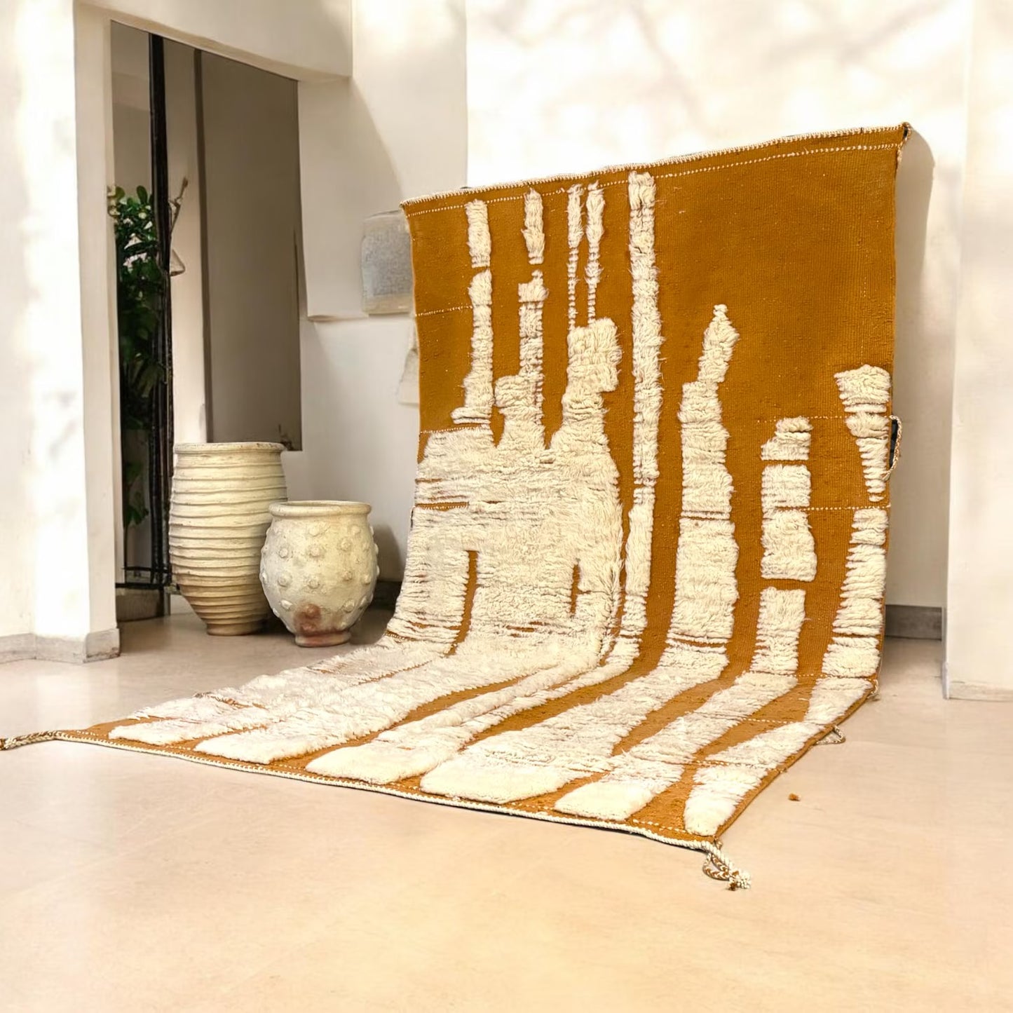 A striking Moroccan wool rug featuring sculpted ivory abstract shapes rising from a deep terracotta base. Handwoven by Amazigh women in the Atlas Mountains using 100% natural wool. This rug blends traditional craftsmanship with a bold, modern design perfect for boho, wabi-sabi, and artistic interiors. Ideal for statement living rooms, studios, or curated spaces.