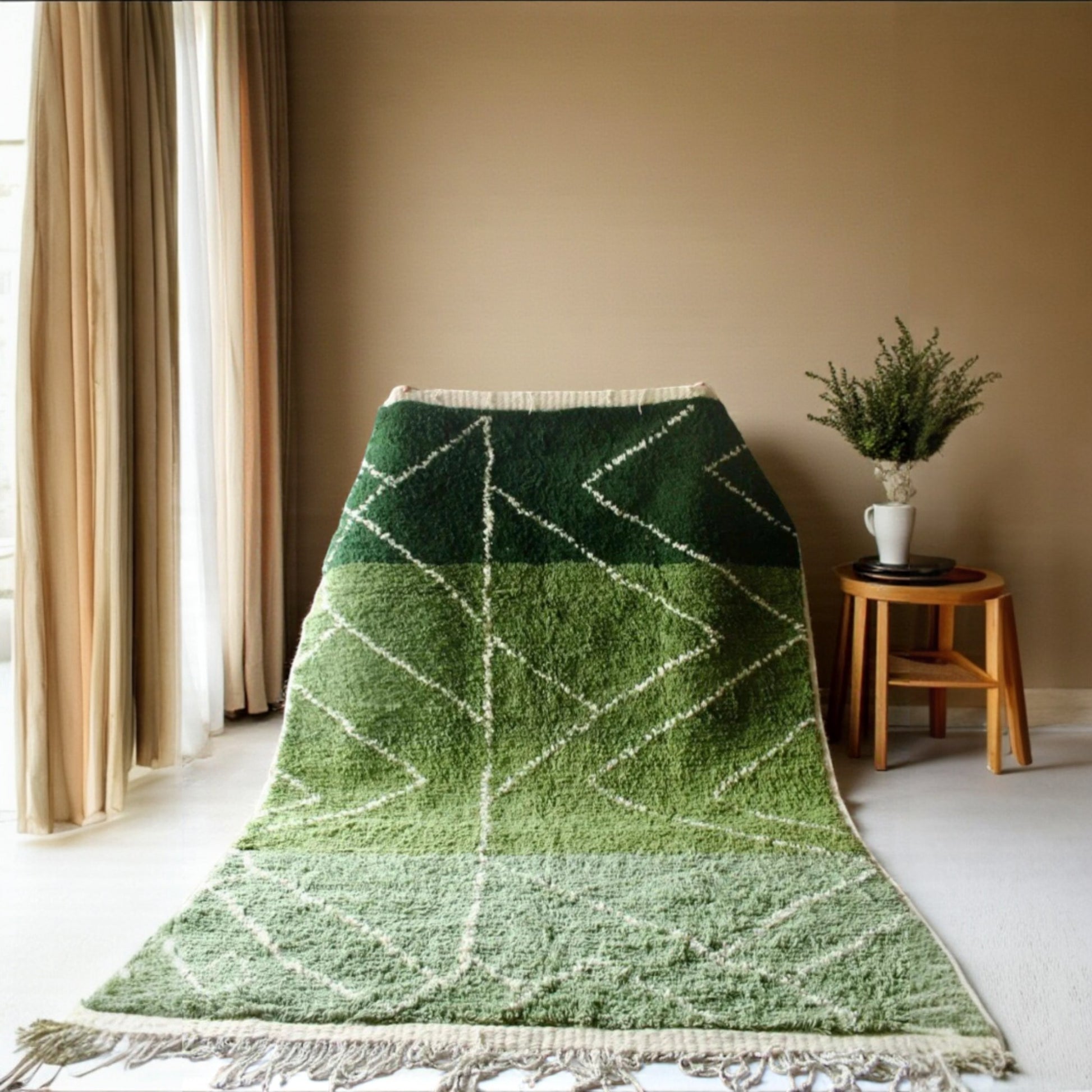 Green geometric patterned rug on a light-colored floor with a beige wall and curtain in the background.